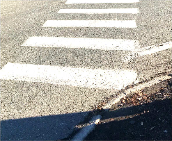 Figure 13 - Lack of Pedestrian Facilities on Southwest Intersection Corner leading to Gleasondale Road (Route 62) Crosswalk. Image is an aerial close-up of where the crosswalk meets the bed of mulch and vegetation, showing that the corner does not include sidewalks or any other pedestrian accommodations. Figure 13 - Lack of Pedestrian Facilities on Southwest Intersection Corner leading to Gleasondale Road (Route 62) Crosswalk. Image is an aerial close-up of where the crosswalk meets the bed of mulch and vegetation, showing that the corner does not include sidewalks or any other pedestrian accommodations.